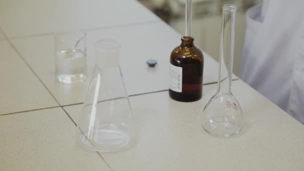 Un scientifique masculin avec éprouvettes dans un laboratoire effectue une expérience . — Video