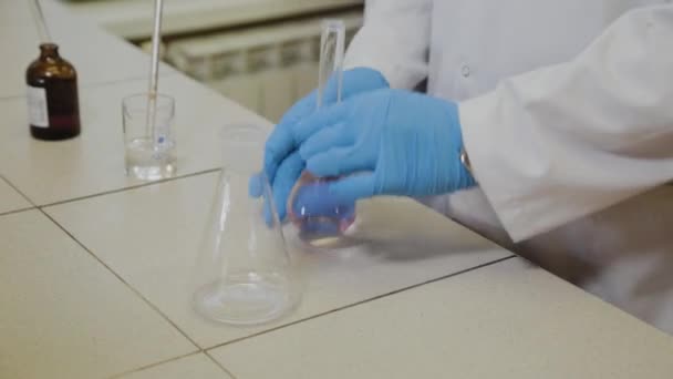Cientista do sexo masculino com tubos de ensaio em laboratório realiza um experimento . — Vídeo de Stock