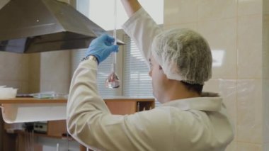 Laboratuvarda deney tüpleri olan bir erkek bilim adamı bir deney yapıyor..