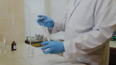 Laboratuvarda deney tüpleri olan bir erkek bilim adamı bir deney yapıyor..