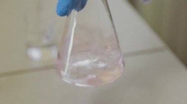 Laboratuvarda deney tüpleri olan bir erkek bilim adamı bir deney yapıyor..