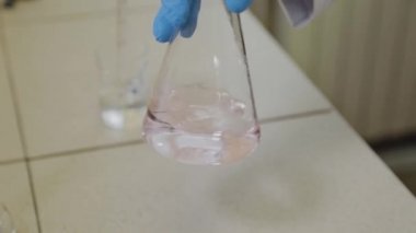 Laboratuvarda deney tüpleri olan bir erkek bilim adamı bir deney yapıyor..