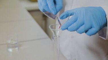 Laboratuvarda deney tüpleri olan bir erkek bilim adamı bir deney yapıyor..