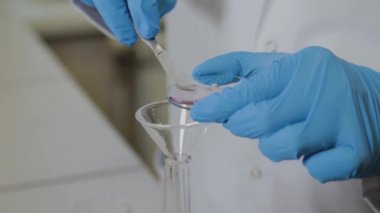 Laboratuvarda deney tüpleri olan bir erkek bilim adamı bir deney yapıyor..