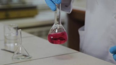 Laboratuvarda deney tüpleri olan bir erkek bilim adamı bir deney yapıyor..