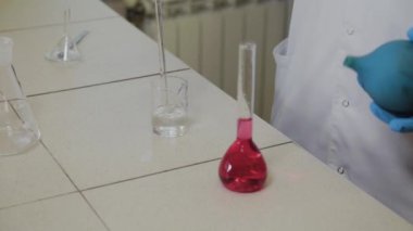 Laboratuvarda deney tüpleri olan bir erkek bilim adamı bir deney yapıyor..