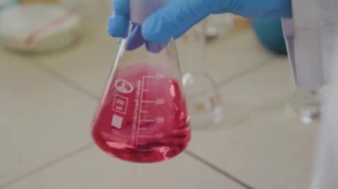 Laboratuvarda deney tüpleri olan bir erkek bilim adamı bir deney yapıyor..