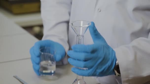 Un scientifique masculin avec éprouvettes dans un laboratoire effectue une expérience . — Video