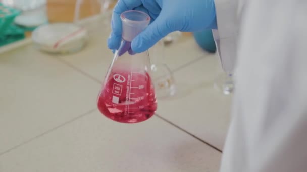 Mužský vědec se zkumavkami v laboratoři provádí experiment. — Stock video