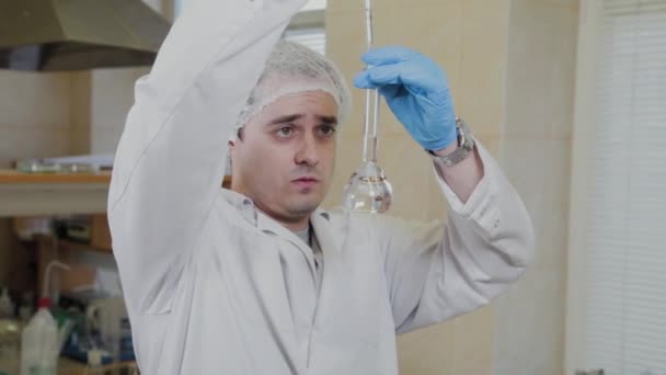 Mužský vědec se zkumavkami v laboratoři provádí experiment. — Stock video