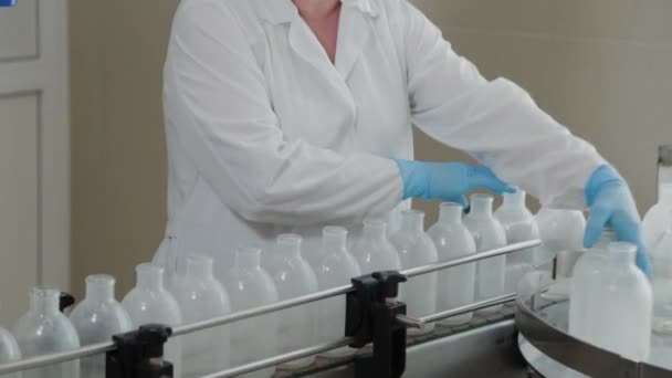 Woman scientist on the conveyor for washing and disinfecting injection bottles. — Stock Video