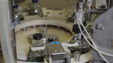 Enjeksiyon için cam şişelere ilaç döküyorum..