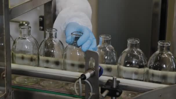Frascos de vidrio para medicamentos estériles en una cinta transportadora para llenar con contenido . — Vídeos de Stock