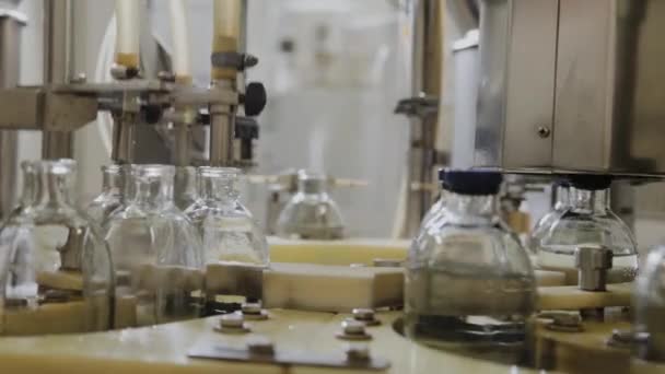 Pouring medicine on an assembly line into glass bottles for injection. — Stock Video