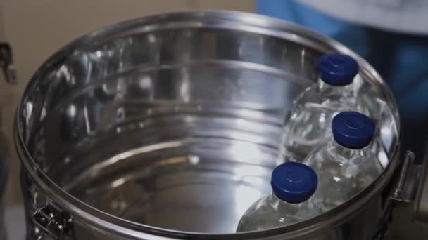 Trabalhador de laboratório coloca garrafas de medicamentos em recipiente de esterilização . — Vídeo de Stock