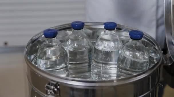 Trabajador de laboratorio pone botellas de medicamentos en el recipiente de esterilización . — Vídeos de Stock