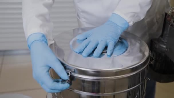 Laboratoriummedewerker stopt medicijnflesjes in sterilisatie container. — Stockvideo