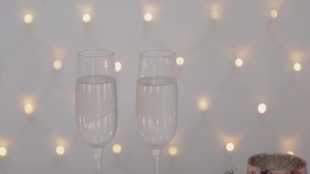 Deux verres de Noël sur un fond lumineux. Nouvel An 2020 . — Video