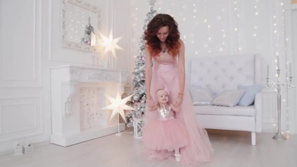 Belle mère avec une fille d'un an dans de belles robes et décor du Nouvel An. Nouvel An 2020 . — Video