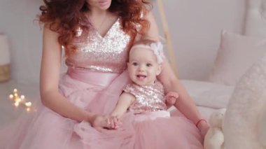 Güzel bir anne, bir yaşında güzel elbiseli bir kız çocuğu ve yeni yıl dekoru. Yeni Yıl 2020.