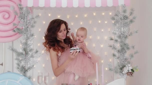 Красива мати з однорічною дочкою в красивих сукнях і новорічному декорі. Новий рік 2020 . — стокове відео
