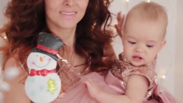 Красива мати з однорічною дочкою в красивих сукнях і новорічному декорі. Новий рік 2020 . — стокове відео
