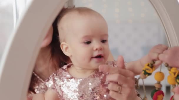 Mooie moeder met een 1-jarige dochter in prachtige jurken en nieuwjaarsdecor. Nieuwjaar 2020. — Stockvideo