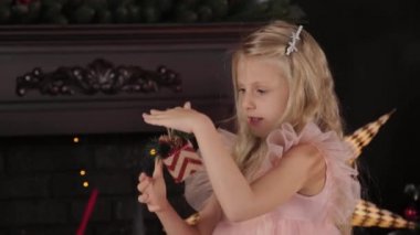 Yeni yıl ağacının yanında 10 yaşında bir kız elinde yeni yıl oyuncağı tutuyor. Yeni Yıl 2020.