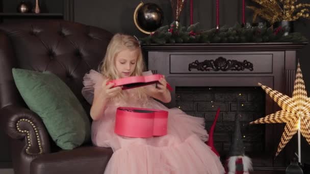 A ten year old happy girl opens a New Years gift. Happy New Year 2020. — Stock Video