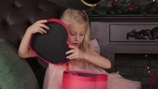 10 살난 행복 한 소녀가 새로운 해의 선물을 엽니다. 행복 한 신년 2020 년. — 비디오