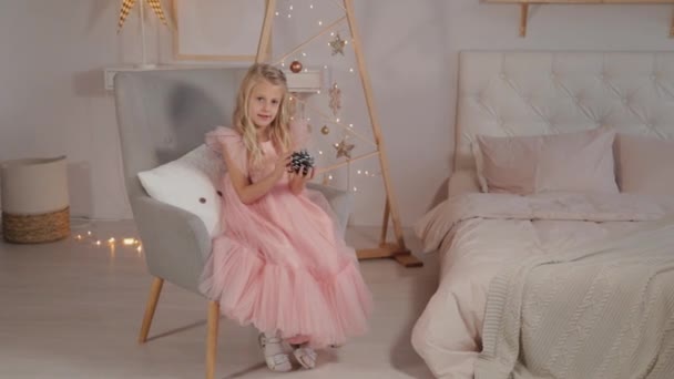 A nine-year-old girl in New Year s decor holds a New Year s toy in her hands. New Year 2020. — Stock Video