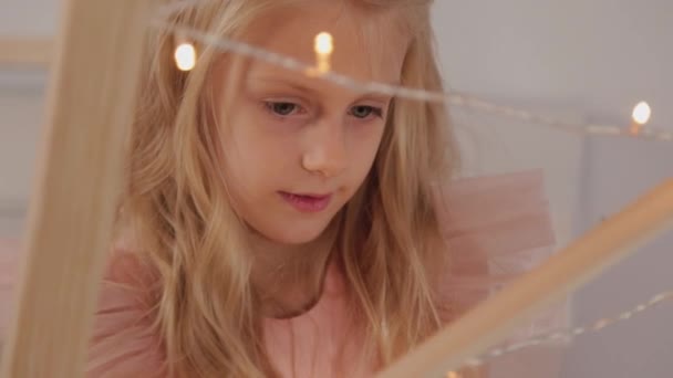 A nine-year-old girl in New Year s decor holds a New Year s toy in her hands. New Year 2020. — Stock Video