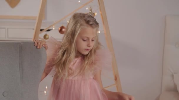 A nine-year-old girl in New Year s decor holds a New Year s toy in her hands. New Year 2020. — Stock Video