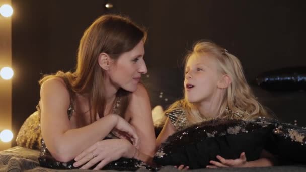 Beautiful and happy mom with a daughter at the New Year tree on the bed. Happy New Year 2020. — Stock Video