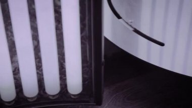 Bir kadın solaryuma girer, bacakları birbirine yakındır..