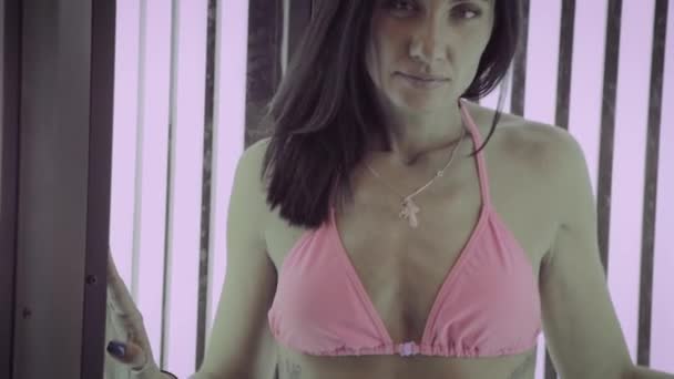 Belle femme bronzer dans le solarium . — Video