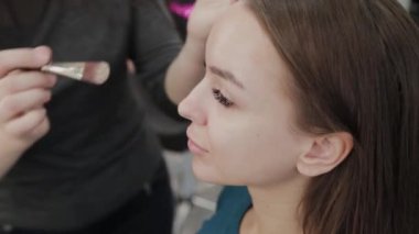 Profesyonel makyöz kadın palette makyaj kremi karıştırıyor..