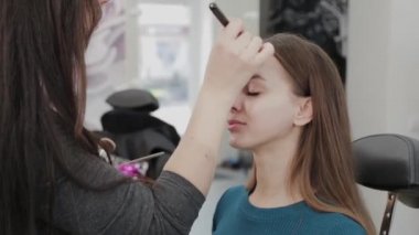 Profesyonel makyöz kadın palette makyaj kremi karıştırıyor..