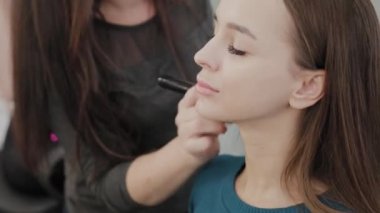 Profesyonel makyöz kadın palette makyaj kremi karıştırıyor..