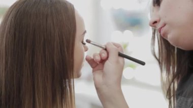 Profesyonel makyöz kadın palette makyaj kremi karıştırıyor..