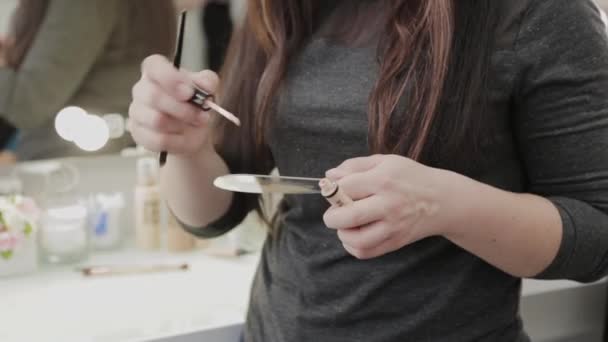 La donna truccatrice professionale mescola la crema di trucco su una tavolozza . — Video Stock