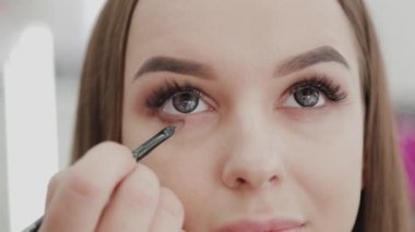 Profesyonel makyöz kadın palette makyaj kremi karıştırıyor..