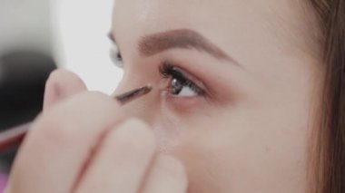 Profesyonel makyöz kadın palette makyaj kremi karıştırıyor..