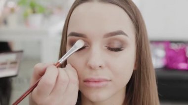 Profesyonel makyöz kadın palette makyaj kremi karıştırıyor..