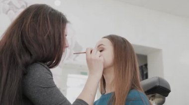 Profesyonel makyöz kadın palette makyaj kremi karıştırıyor..