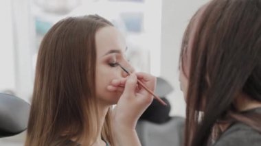 Profesyonel makyöz kadın palette makyaj kremi karıştırıyor..