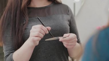 Profesyonel makyöz kadın palette makyaj kremi karıştırıyor..