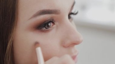 Profesyonel makyöz kadın palette makyaj kremi karıştırıyor..