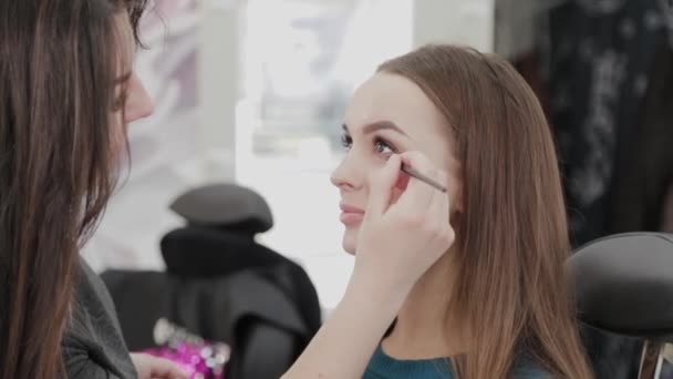 Επαγγελματική makeup artist γυναίκα αναδεύει κρέμα μακιγιάζ σε μια παλέτα. — Αρχείο Βίντεο