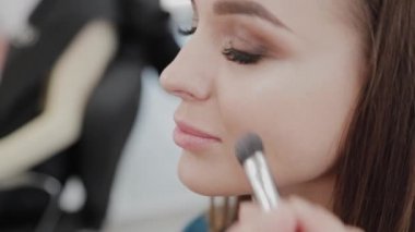 Profesyonel makyöz kadın palette makyaj kremi karıştırıyor..